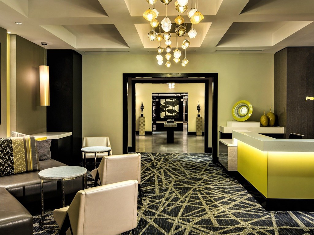 A large room with a black and white patterned carpet and a chandelier hanging from the ceiling.