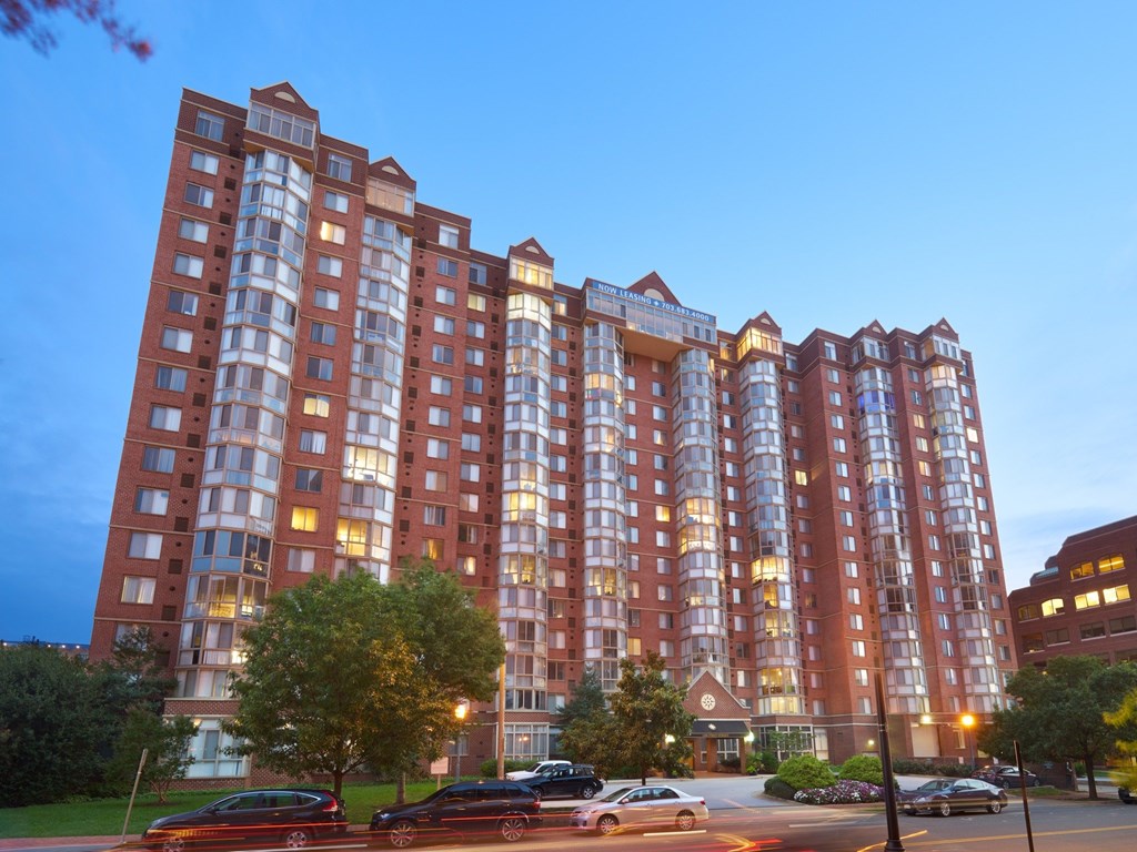 A large red brick building with a parking lot in front of it.