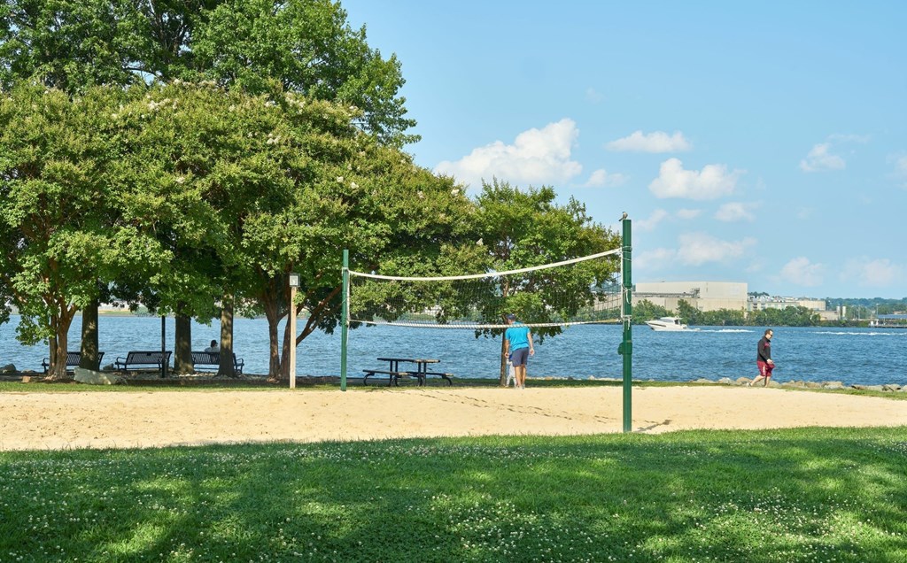 A beach volleyball net is set up on a sandy beach.