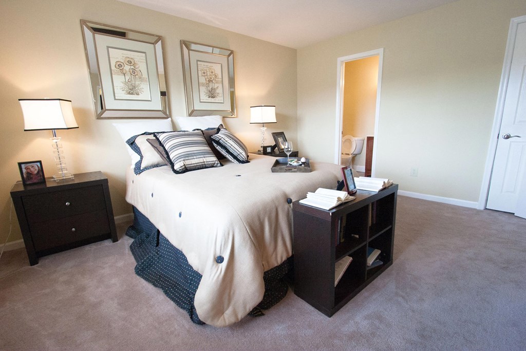 a bedroom with a bed and two nightstands and a mirror