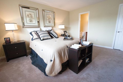 a bedroom with a bed and two nightstands and a mirror
