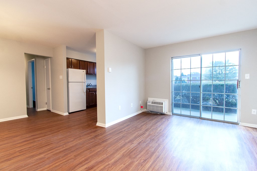 an empty living room with wood flooring and a large window