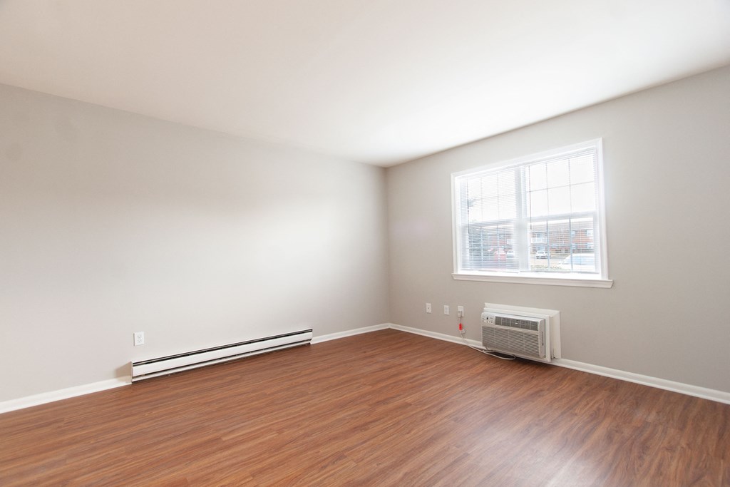 an empty room with wood floors and a window