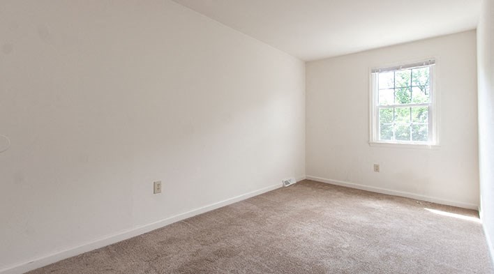 an empty room with carpet and a window