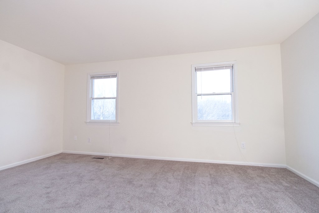 an empty room with two windows in it