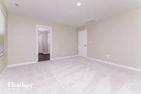 A spacious empty room with a doorway leading to another room.