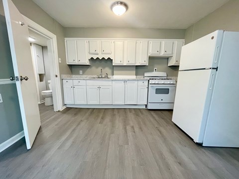 A kitchen with white cabinets and appliances.