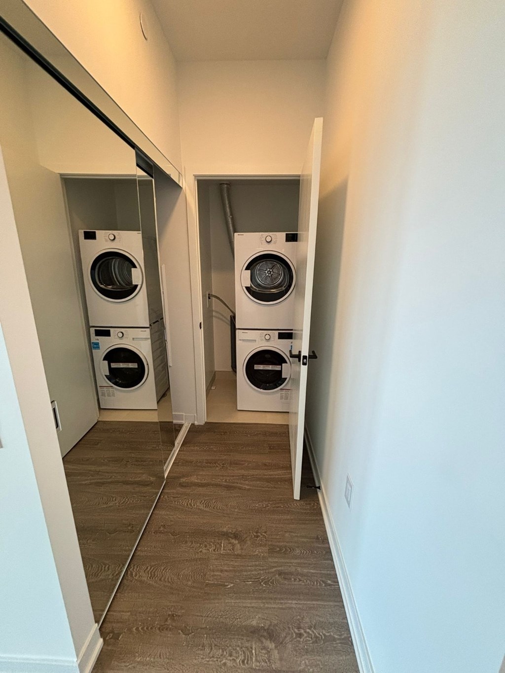 A hallway with two washing machines on either side.