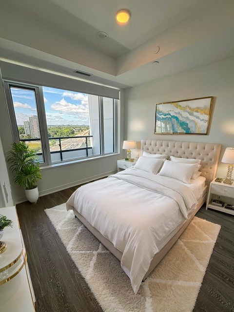 A bedroom with a large bed and a view of the city.