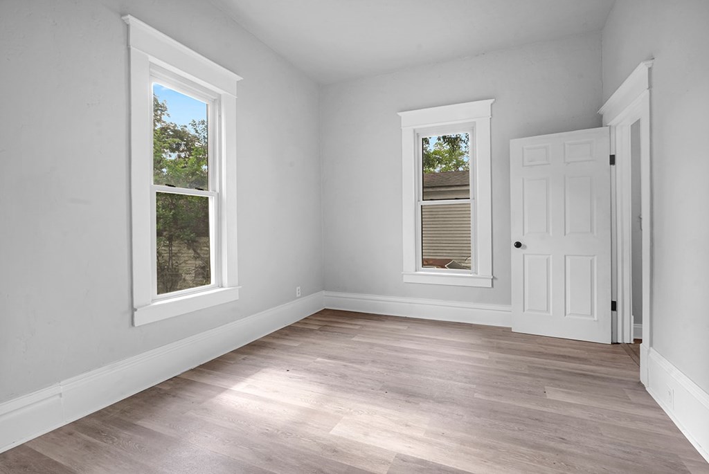A room with a white door and a window with blinds.