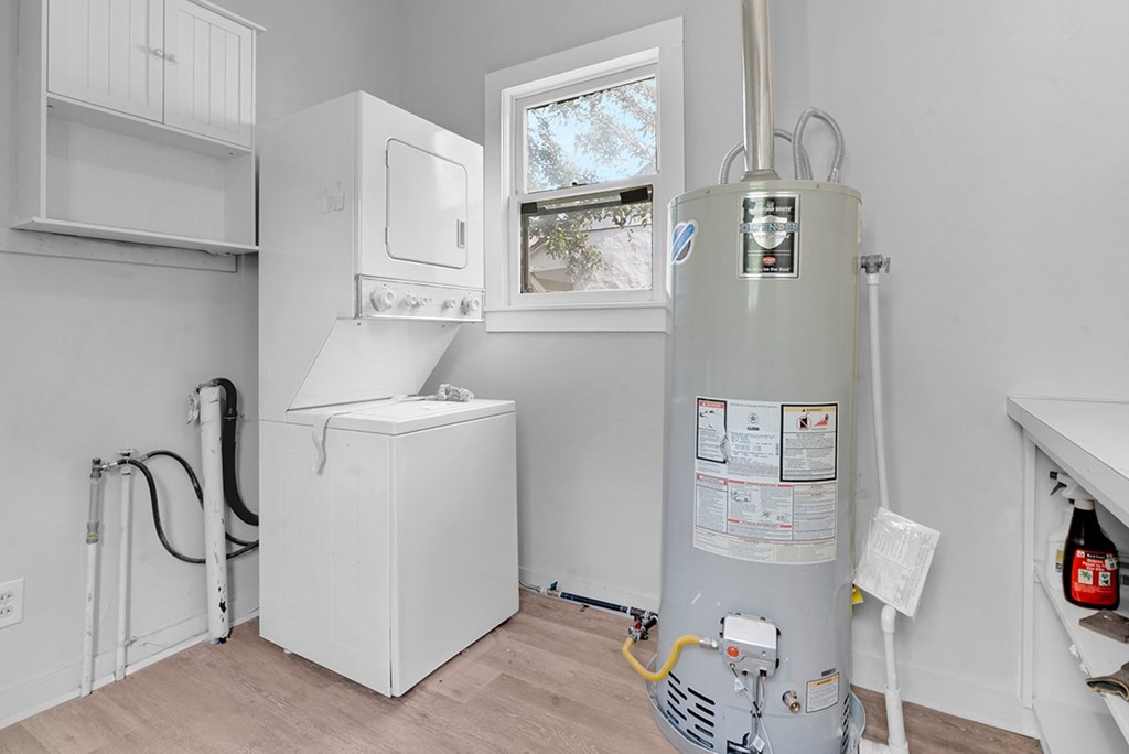 A white tankless water heater with a manual on the side and a window above it.