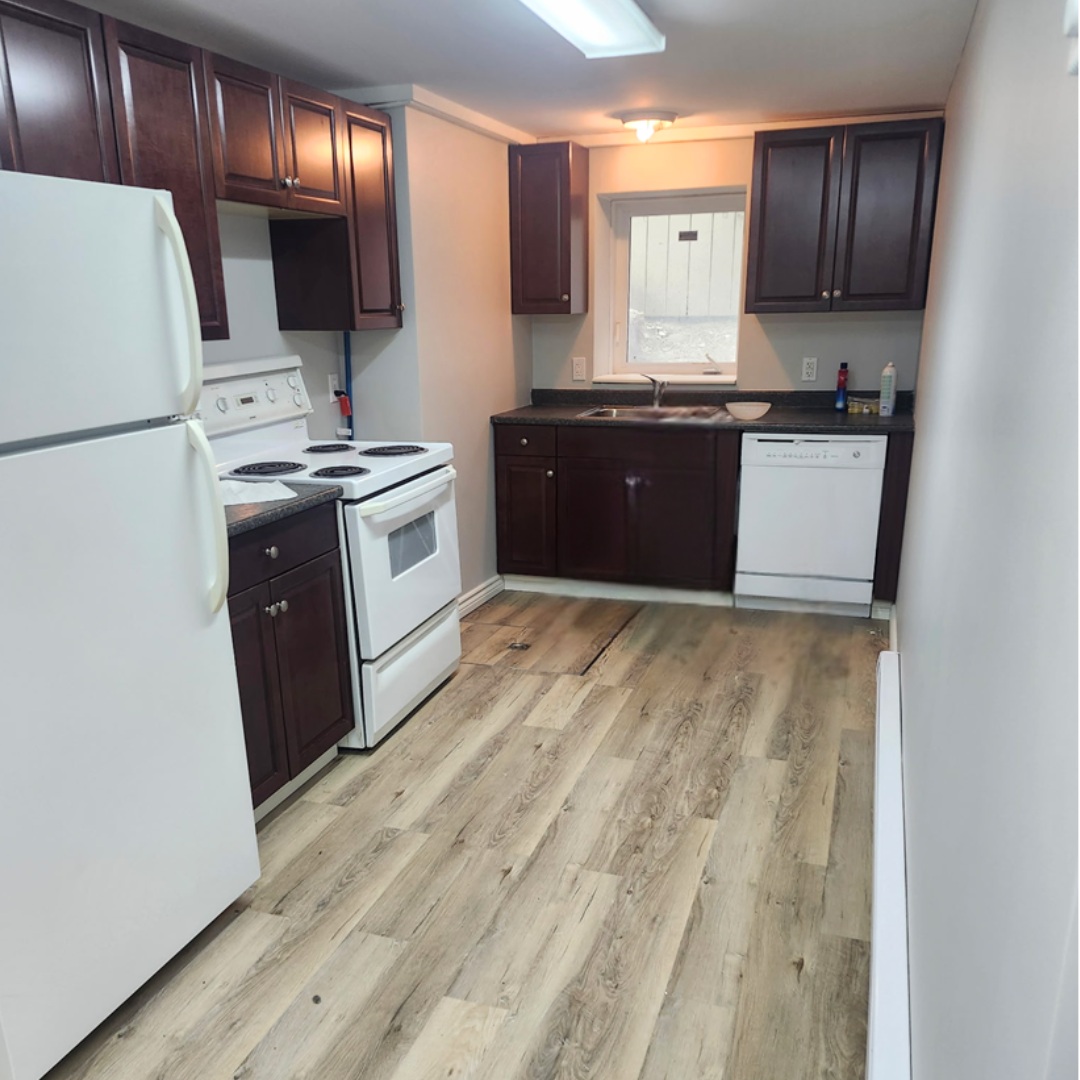 A kitchen with a white fridge, white stove, and white dishwasher.