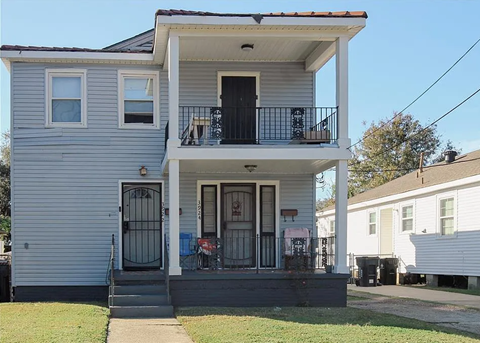 A two-story house with a balcony on the second floor.