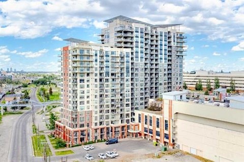 A large multi-story building with a parking lot in front.