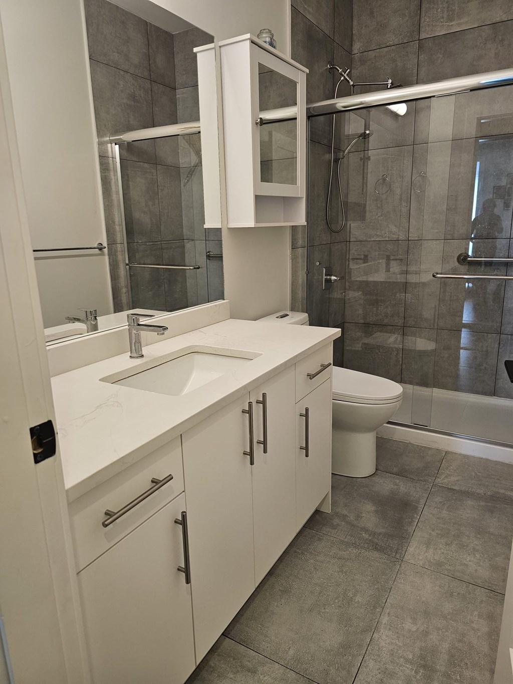 A bathroom with a white sink and toilet.