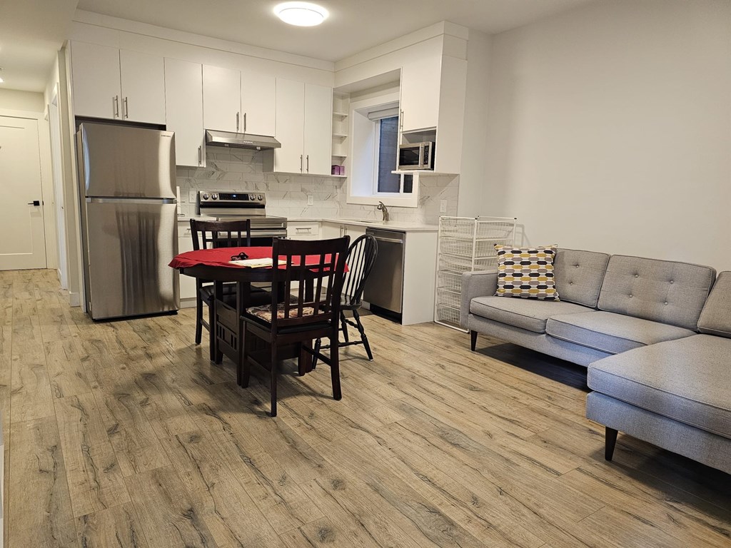 A kitchen with a table and chairs and a couch.