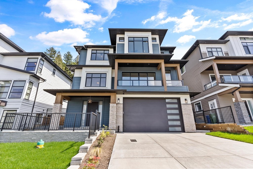 A modern two-story house with a garage and a well-maintained lawn.