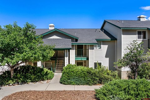 A house with a green front door and a grey roof.