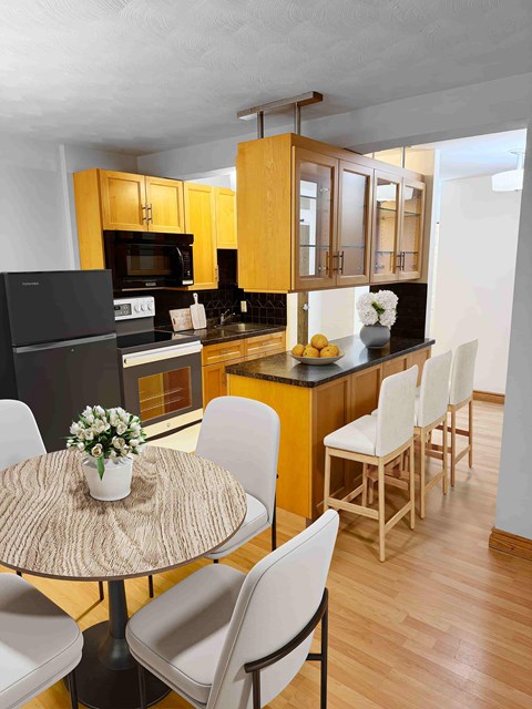 A kitchen with a table and chairs.