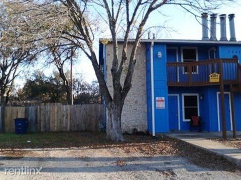 A blue building with a tree in front of it.