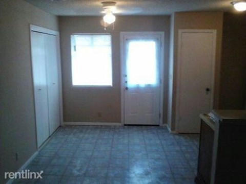 A room with a tile floor and two windows.