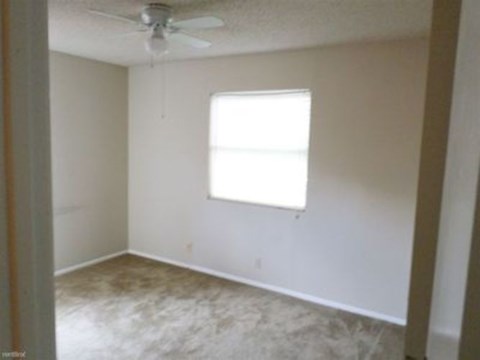 A room with a ceiling fan and a window.