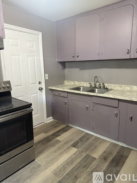 A kitchen with purple cabinets and a black oven.