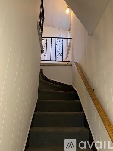 A staircase with a metal railing and wooden handrail.