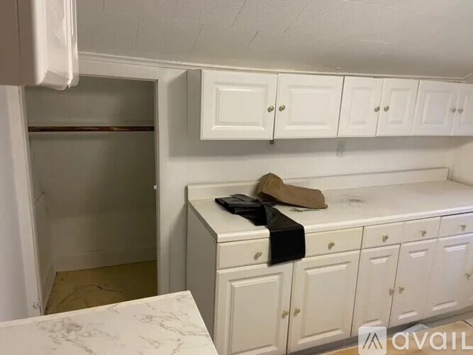 A kitchen with white cabinets and a marble countertop.