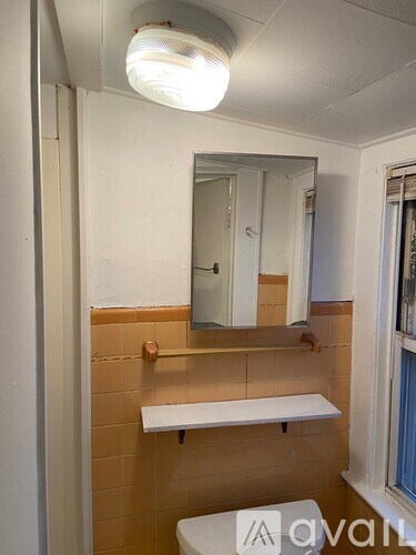A bathroom with a mirror and a light above it.