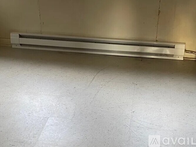 A long metal shelf is mounted on a wall.