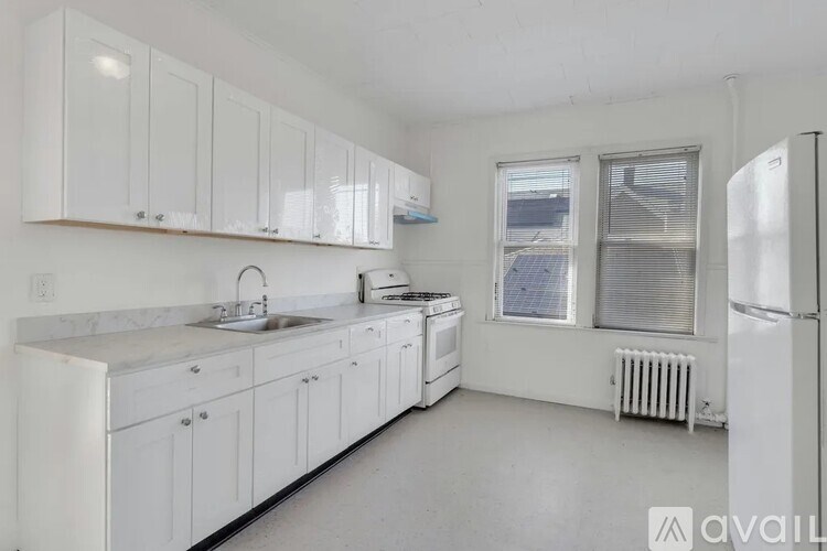 A kitchen with white cabinets and appliances.