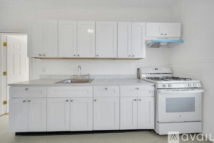 A kitchen with white cabinets and appliances.