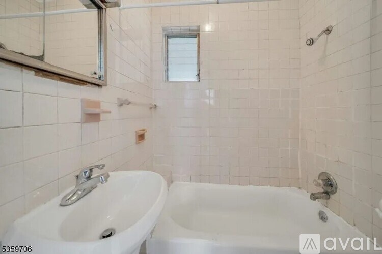 A bathroom with a white sink and bathtub.