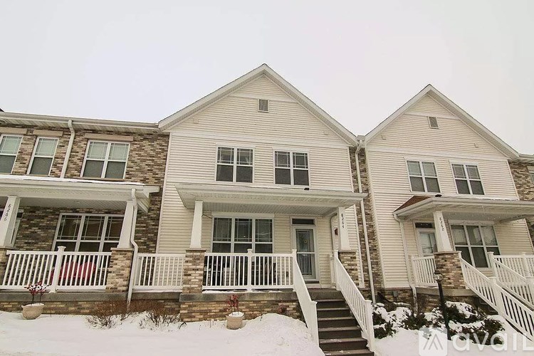 A row of houses with snow on the ground.
