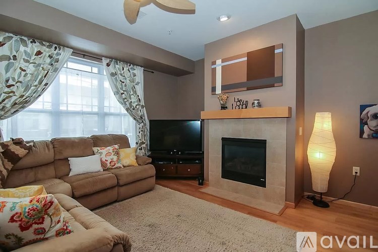 A living room with a couch, television, and fireplace.