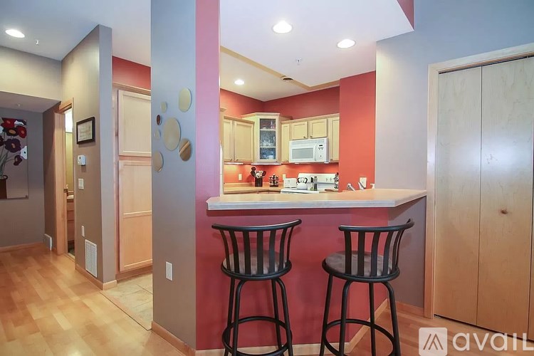 A kitchen with a bar stool in front of the counter.