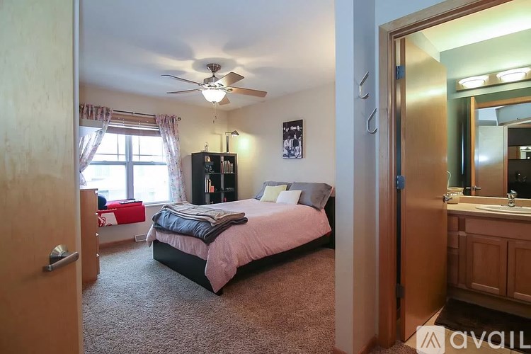 A bedroom with a bed, dresser, and window.