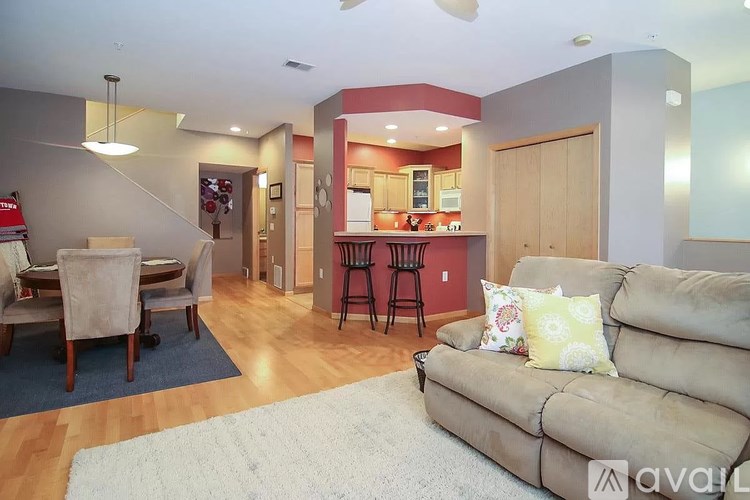 A living room with a couch, chairs, and a dining table.