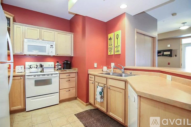 A kitchen with a white stove and wooden cabinets.