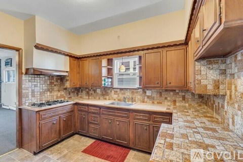 A kitchen with wooden cabinets and a stone backsplash.