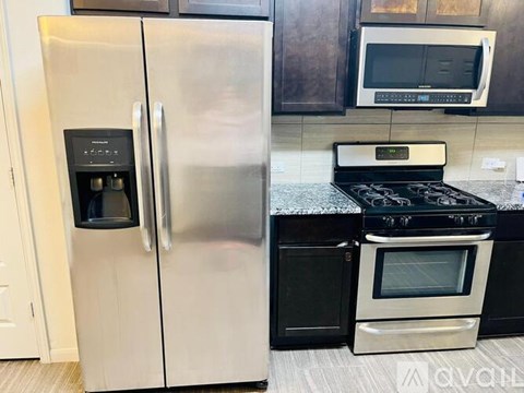 A stainless steel refrigerator with a digital display on the door stands in a kitchen.