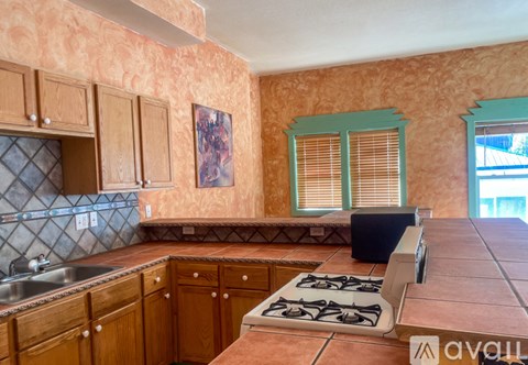 A kitchen with wooden cabinets and a tiled backsplash.