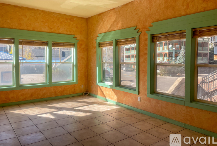 A room with green windows and orange walls.