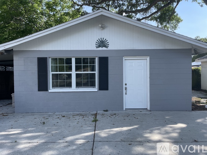 A small house with a white door and black window frames.