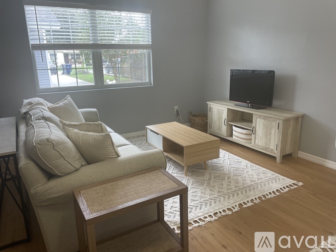 A living room with a couch, a coffee table, and a television.