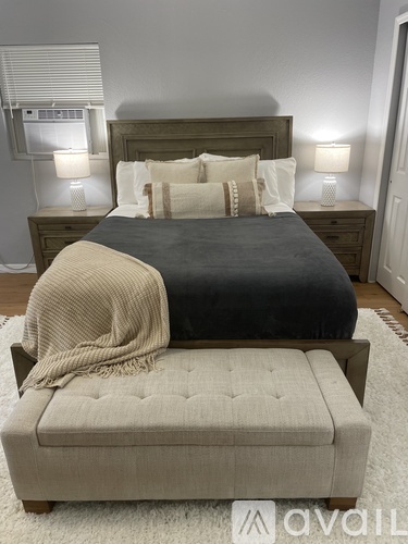 A bedroom with a bed, nightstands, and a bench.
