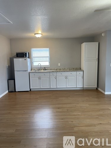 A kitchen with white appliances and cabinets.