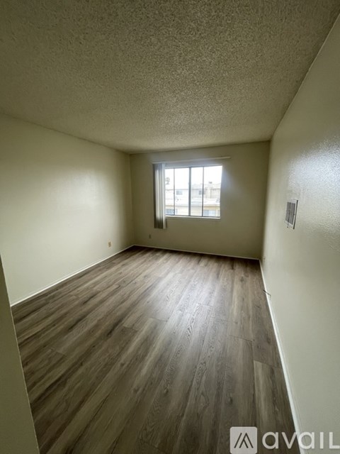 A room with wooden flooring and a window.
