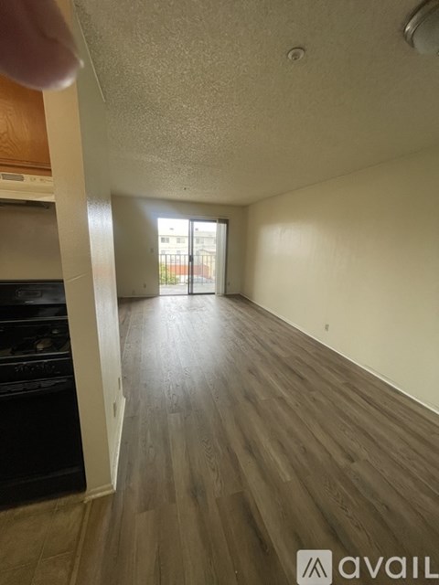 A room with wooden flooring and a doorway leading to another room.
